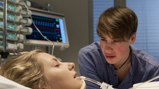 Nico (Jeremy Mockridge) weint am Krankenbett: Caro (Cynthia Cosima) liegt noch immer im Koma.