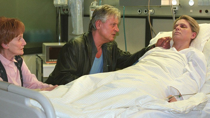 Rosi (Margret van Munster, links) und Andy (Jo Bolling) besuchen Gabi (Andrea Spatzek) am Krankenbett. Noch ist unklar, ob der Autounfall bleibende Schäden hinterlassen hat.