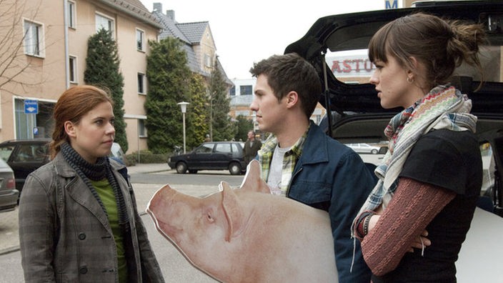 Schwein gehabt: Felix (Oliver Moser) will mit Jack (Cosima Viola, rechts) gegen klimafeindliche Schweinemast demonstrieren. Sarah (Julia Stark) lehnt es ab, dabei mitzumachen.