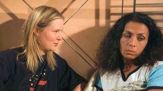 Suzanne (Susanne Evers, rechts) ist dagegen, dass sich Tanja (Sybille Waury) untersuchen lässt.