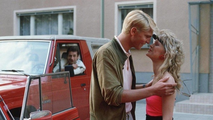 Tanja (Sybille Waury) provoziert Stefan Nossek (Dietrich Siegl, hinten) mit einem neuen Freund.
