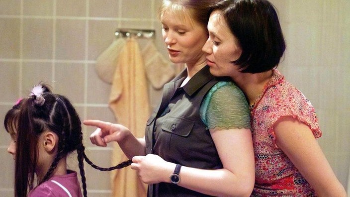 Urszula (Anna Nowak, rechts) staunt über Tanjas (Sybille Waury) Fingerfertigkeit beim Flechten von Irinas (Karolin Dubberstein) Haaren. So wird sie ihre Gesellenprüfung ohne Probleme bestehen.