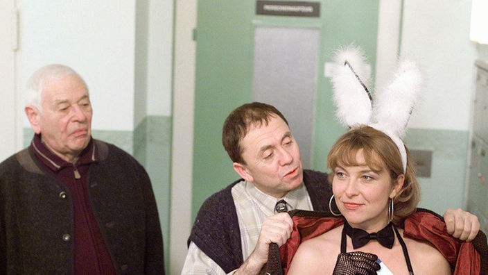 Verwundert registriert Oskar (Reinhold Lampe, links), dass Olaf (Franz Rampelmann) einer unbekannten Schönen (Cornelia de Pablos) ins Kleid hilft.