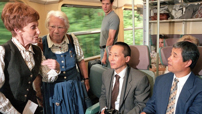 Völker-Verständigung: Rosi (Margret van Munster, links) und Frau Birkhahn (Hanna Burgwitz) streiten im Zug mit zwei Japanern um die Sitzplätze.