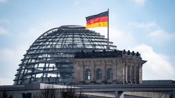 Die Kuppel des Reichstags in Berlin mit Deutschland-Flagge