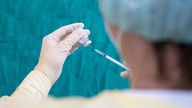 Eine Krankenschwester zieht den Impfstoff gegen das Coronavirus mit einer Spritze auf 