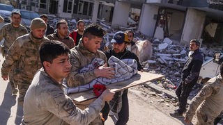 Soldaten tragen ein Baby, das 59 Stunden nach dem Erdbeben gerettet wurde.