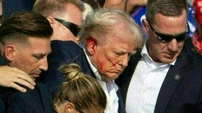 Trump mit blutendem Ohr ist umringt von Secret Service Mitarbeitern