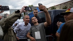 Ein junger Mann macht ein Selfie mit Höcke