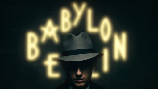 Kopf eines Mannes mit dunklem Hut im 20er-Jahre-Stil vor einer unscharfen Neonschrift "Babylon Berlin"
