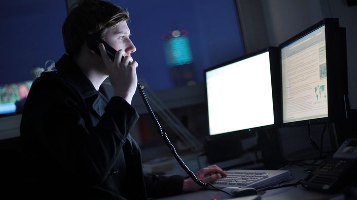 Symbolfoto: Mann im dunklen Büro am Computerarbeitsplatz