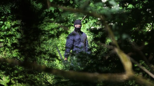 Maskierter Mann in Uniform an der kroatisch-bosnischen Grenze