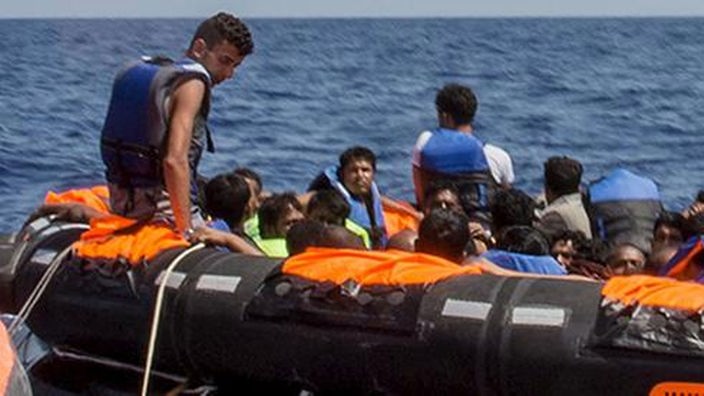 Flüchtlinge sitzen im Schlauchboot