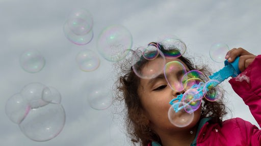 Ein kleines Mädchen macht Seifenblasen