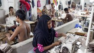 Eine Frau und mehrere Kinder nähen Kleidung in der bangladeschischen Stadt Dhaka.