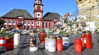 Das Bild zeigt niedergelegte Kerzen und Blumen in Mannheim. 