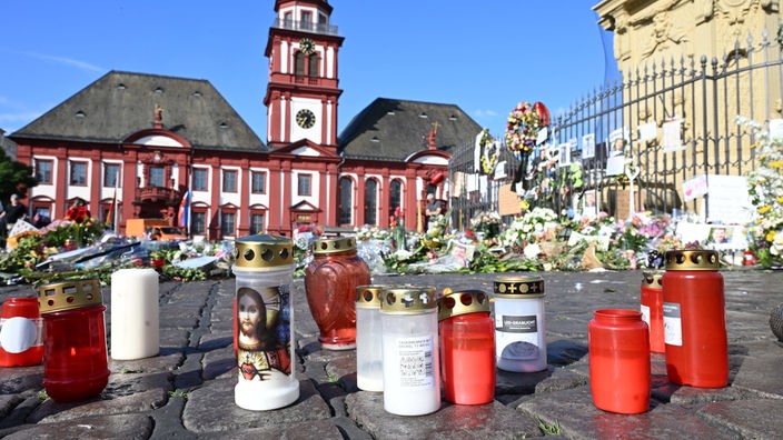 Das Bild zeigt niedergelegte Kerzen und Blumen in Mannheim. 