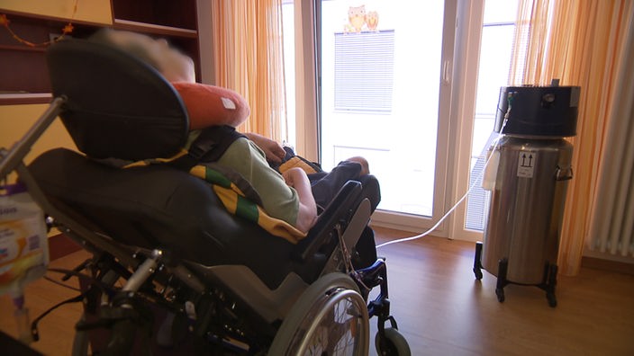 Patientin von hinten in einem Rollstuhl sitzend