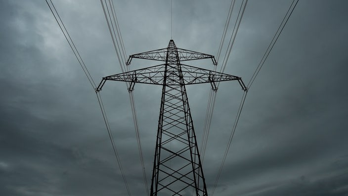 Blackout: Ein Strommast vor einem dunklen Himmel, fotografiert aus der Froschperspektive