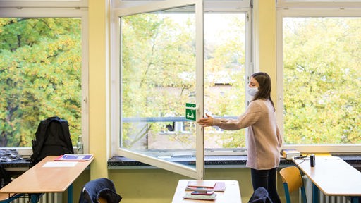 Eine Schülerin der Stadtteilschule Niendorf in Hamburg öffnet das Fenster.