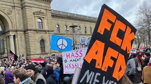 Demonstranten stehen mit Plakaten vor dem Magdeburger Hauptbahnhof bei einer Demonstration gegen rechts (04.02.2024).