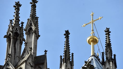 Ein goldenes Kreuz auf dem Kölner Dom