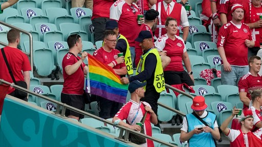 Ordner nehmen zwei Dänemark-Fans im Baku Olympic Stadium eine Regenbogen-Fahne ab.