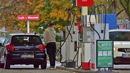 Junger Mann tankt sein Auto an der Tanskstelle auf. 