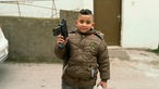  Ein Kind im Flüchtlingslager von Jenin spielt mit einer aussortierten Waffe.