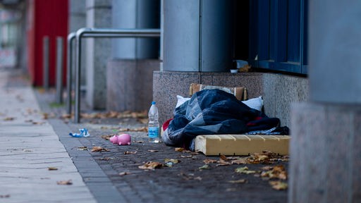 Ein Obdachloser schläft in einer Einkaufsstraße in Dortmund.
