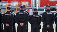 Bundespolizisten stehen auf einem Übungsgelände vor einem restaurierten Doppelstock-Waggon.