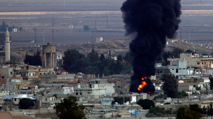 Rauch steigt über der syrischen Stadt Ras al-Ain auf, die zuvor durch die türkischen Streitkräfte bombardiert wurde.