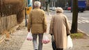 Ein Rentnerpaar trägt Plastiktüten mit Einkäufen.