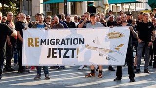 Demonstrierende zeigen ein Banner mit der Aufschrift "Remigration jetzt!" am 26.08.2024 in Solingen