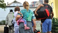 Flüchtlingsfamilie mit Kindern und Gepäck