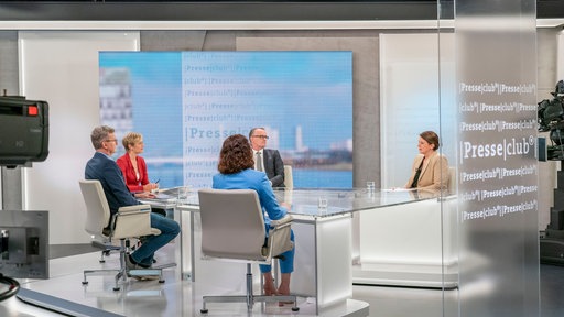 Die Gäste der Sendung sitzen am Tisch des Presseclubstudios