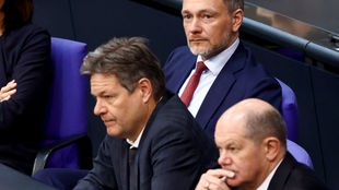 Christian Lindner (FDP), Robert Habeck (Bündnis 90/Die Grünen) und Olaf Scholz (SPD) sitzen nebeneinander im Bundestag, besorgte Gesichter