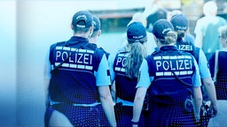 Von hinten zu sehende Polizist:innen, die in einer Menschenmenge unterwegs sind