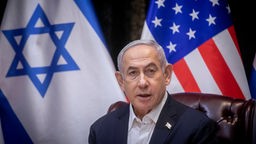 Die Flaggen von Israel und den USA, im Vordergrung sitzt Israels Ministerpräsident Netanjahu