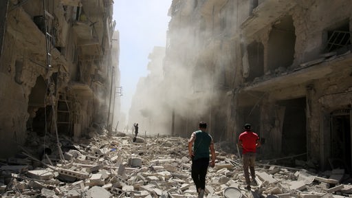 Männer begutachten den Schaden nach einem Luftangriff auf das von Rebellen gehaltenen Viertel al-Quaterji in Aleppo