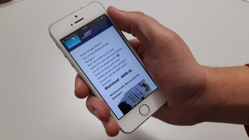 Hand hält ein Smartphone mit einer geöffneten App