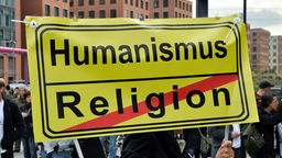 Plakat auf dem oben Humanismus steht und unten durchgestrichen Religion
