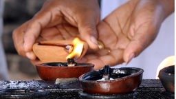 Ein Buddhist zündet eine Kerze an
