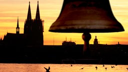 Schwebende Glocke über Rheinpanorama mit Kölner Dom