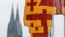 Kirchentagsfahnen wehenvor der Kulisse des Kölner Doms