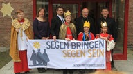 Sternsinger mit Kardinal Meissner und Mitarbeitern vor einer Tür