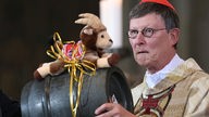 Erzbischof Rainer Maria Woelki nimmt als Geschenk der Kölner Gemeinden ein Fass Kölsch entgegen