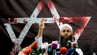 Salafistenprediger Achmed Al-Assir vor einem blutverschmierten Davidstern