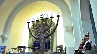 Ein Mitglied der jüdischen Gemeinde Köln hält eine Thorarolle in der Synagoge