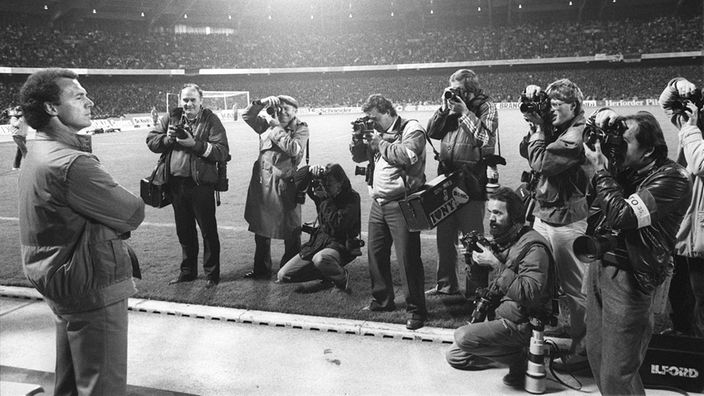 DFB-Teamchef Franz Beckenbauer 1984 vor Fotografenpulk